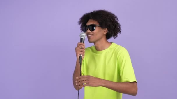 クレイジーロック歌手男歌うマイクダンスディスコ隔離された明るい色の背景 — ストック動画