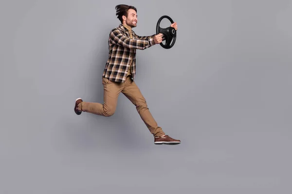 Photo of impressed funny man wear plaid shirt jumping high driving car isolated grey color background — Stockfoto