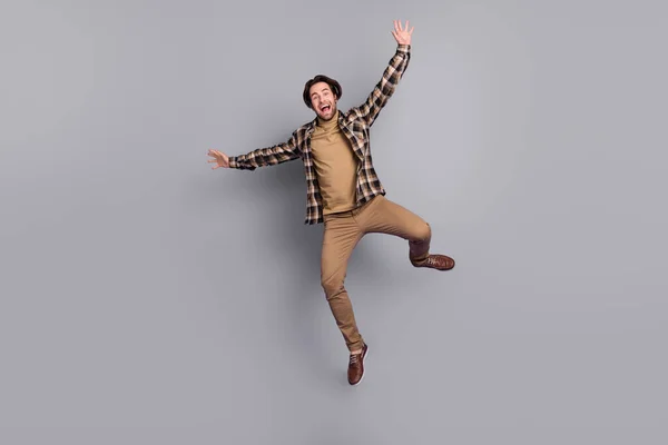 Photo of funny charming man wear plaid shirt jumping high like star isolated grey color background — Stok fotoğraf