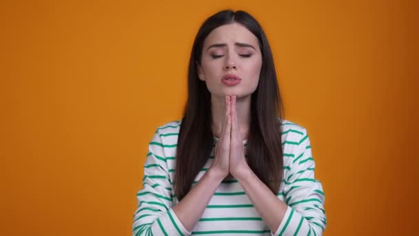 Frustrated lady hands together plead wait isolated mustard color background — Stock video