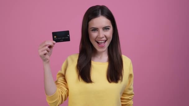 Emocionado lady point tarjeta de crédito ofrecen ahorros aislados pastel color fondo — Vídeos de Stock