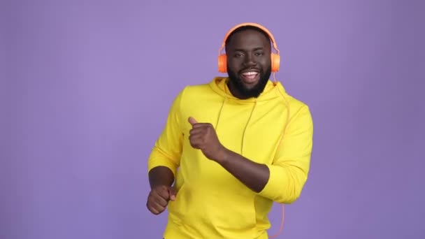 Dynamic guy listen stereo headset dance isolated vibrant color background — Vídeo de Stock