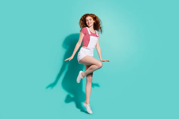 完全長ボディサイズビューの魅力的な陽気な女の子ジャンプ楽しみ孤立した明るい青の色の背景 — ストック写真
