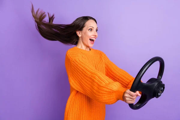 Profile photo of excited cheerful lady hold steering wheel have fun wear orange sweater isolated purple color background — Stok fotoğraf