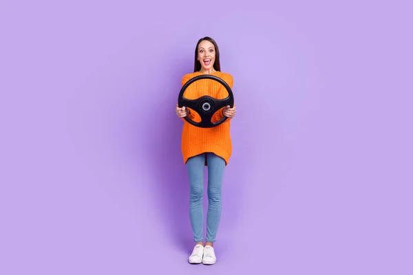 Photo of funny nice glad lady hold steering wheel wear orange sweater jeans footwear isolated purple color background — Foto Stock