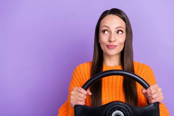 Photo of curious dreamy lady hold steering wheel look empty space wear orange sweater isolated purple color background — Stok fotoğraf