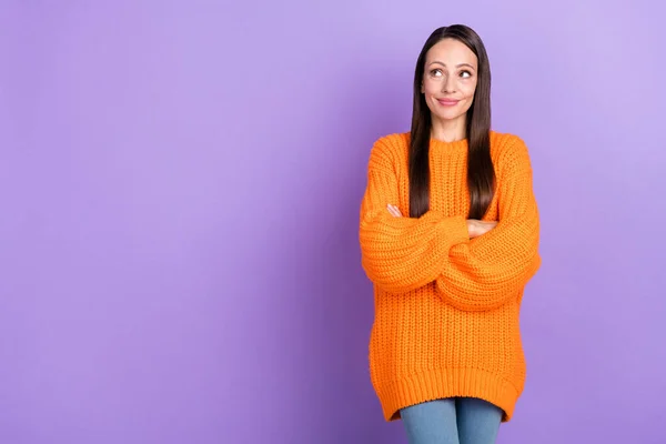 高価な思慮深い女性の折り畳まれた腕の写真空のスペースは、オレンジ色のセーター孤立紫色の背景を身に着けている — ストック写真