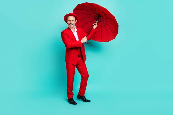 Full length photo of aged groomed man god mood hold parasol autumn isolated over turquoise color background — Stok Foto