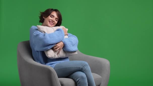 Señora positiva sentarse muebles abrazo almohada aislado brillo color fondo — Vídeo de stock