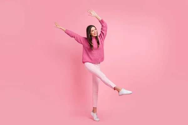 フルサイズ写真のブルネット楽観的な女の子ダンスウェアピンクセーターパンツスニーカー絶縁上深紅色の背景 — ストック写真