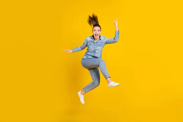 Full length body size photo young pretty girl jumping up showing rock heavy metal sign isolated vivid yellow color background — Stockfoto