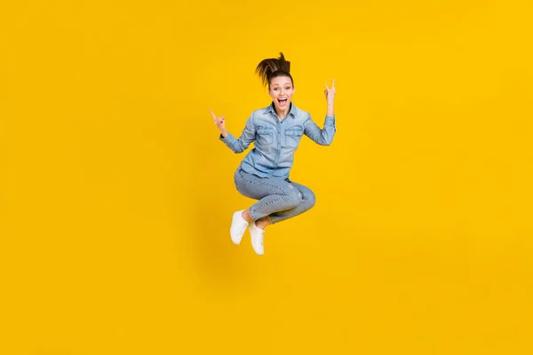 Full length body size photo young pretty girl jumping up showing heavy metal sign isolated vivid yellow color background — Stok fotoğraf