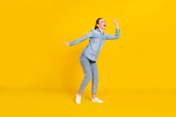 Full length φωτογραφία της λαμπερής αστεία νεαρή γυναίκα φορούν denim πουκάμισο χαμογελώντας χορό απομονωμένο κίτρινο χρώμα φόντο — Φωτογραφία Αρχείου