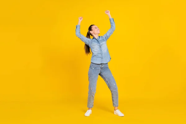 Foto de longitud completa de bastante funky joven dama vestida jeans camisa saltando sonriendo aislado color amarillo fondo — Foto de Stock
