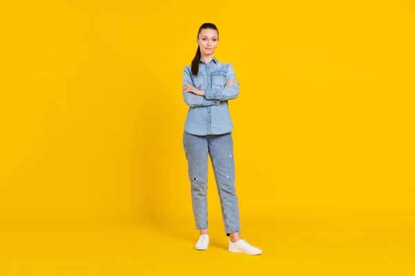 Full size photo of confident serious young woman hold hands crossed wear shoes isolated on yellow color background — стоковое фото