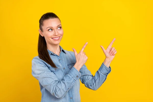 Foto retrato mujer feliz señalando los dedos espacio en blanco sonriendo aislado color amarillo brillante fondo —  Fotos de Stock
