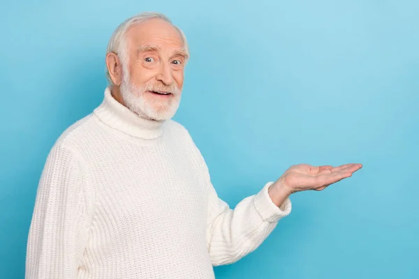 Фото оптимистичного пожилого человека провести промо носить белый свитер изолированы на синем фоне цвета — стоковое фото