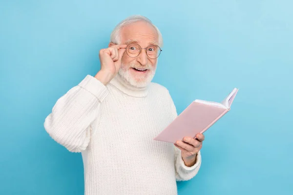 Foto de hombre mayor impresionado leer libro gafas de desgaste jersey aislado sobre fondo de color azul —  Fotos de Stock