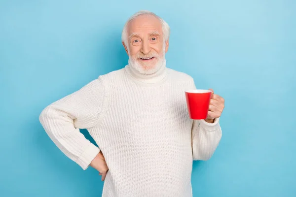 魅力的な陽気な灰色の髪の男の肖像画明るい青の色の背景に隔離されたラテカフェインカプチーノを飲む — ストック写真