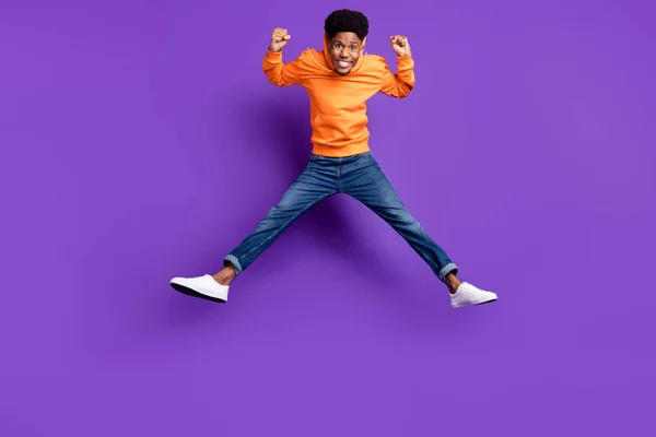 全长体形的迷人的快乐的小伙子欢欣鼓舞地跳着，隔离在明亮的紫色背景下 — 图库照片