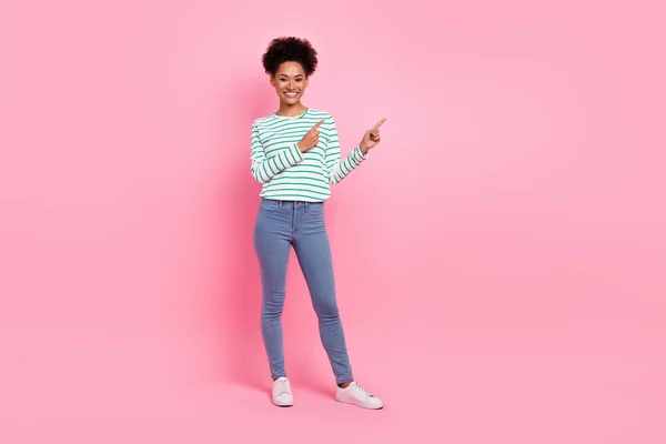 Volledige lengte lichaamsgrootte uitzicht van aantrekkelijke vrolijke meisje demonstreren kopieerruimte ad look idee geïsoleerd over roze pastel kleur achtergrond — Stockfoto