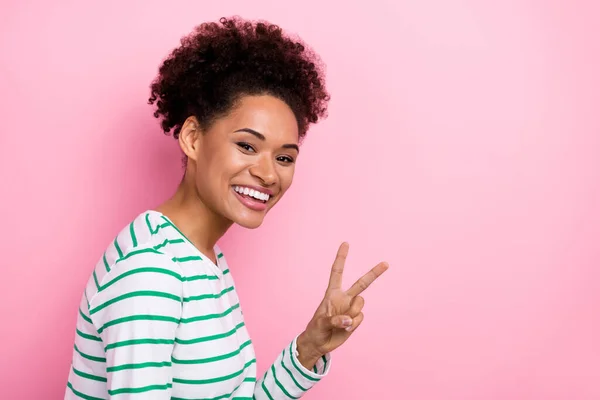 Profile side view portrait of attractive cheerful girl showing v-sign copy space isolated over pink pastel color background — Stockfoto