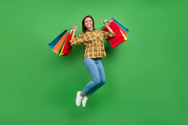 Volledige lengte foto van opgewonden gelukkig aantrekkelijke persoon verhogen pakketten hebben goede stemming geïsoleerd op groene kleur achtergrond — Stockfoto