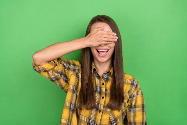 Photo of overjoyed young person arm palm covering eyes toothy smile isolated on green color background — Stockfoto