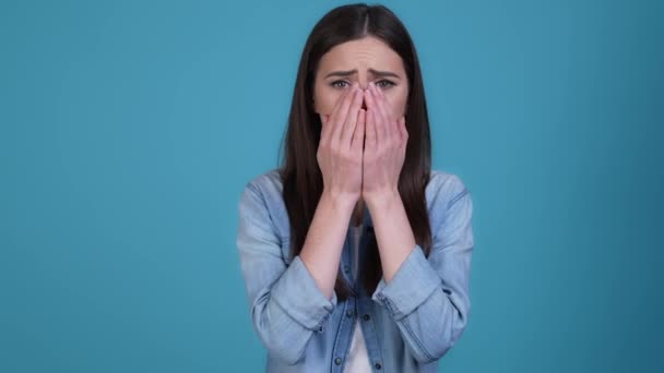 Dame mains fermées bouche se sentir déçu isolé fond de couleur bleue — Video