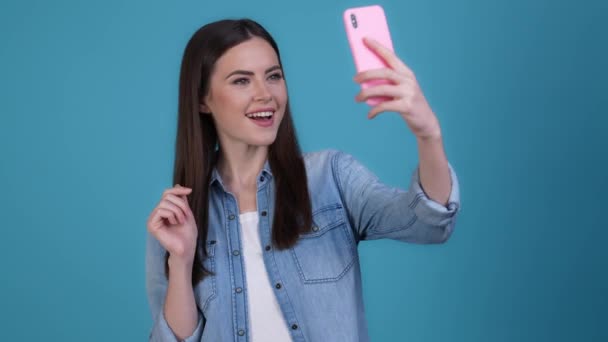 Lady influencer, hogy szelfi v-jel küld sms elszigetelt kék szín háttér — Stock videók