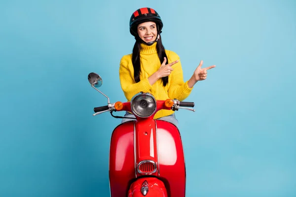 Foto wanita yang mengendarai skuter menunjukkan jari-jari tampak kosong sisi ruang memakai helm penarik kuning terisolasi latar belakang biru — Stok Foto