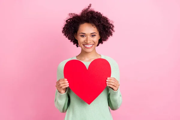 Retrato de encantadora persona de piel oscura positiva sostiene el símbolo del corazón postal aislado en el fondo de color rosa —  Fotos de Stock