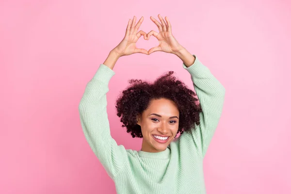 Photo of pretty peaceful dark skin girl make heart symbol above head toothy smile isolated on pink color background — Stock Fotó