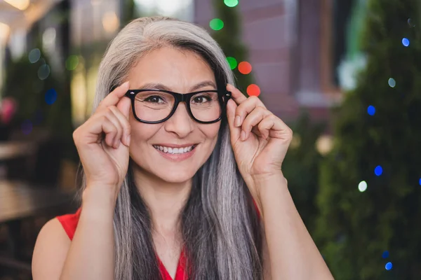 Photo of mature cheerful asian woman happy positive smile hands put eyeglasses vision summer outdoors — Fotografia de Stock