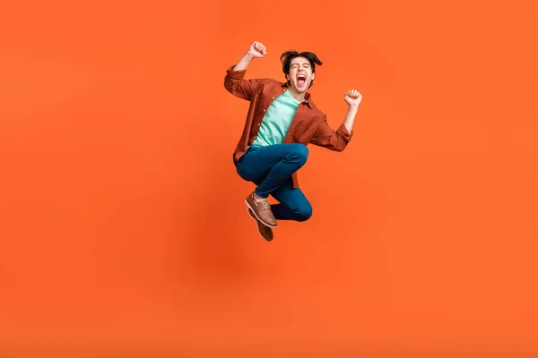 Full size photo of excited crazy smiling male jumping raise fists in victory triumph isolated on orange color background — Foto Stock