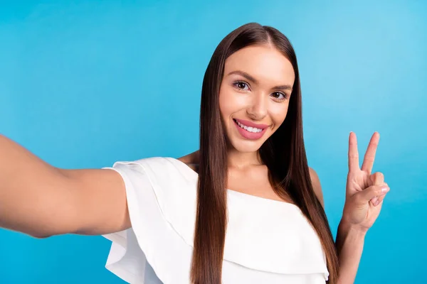 Foto de amigable blogger lady hacer selfie show v-sign usar blusa blanca aislado color azul fondo — Foto de Stock