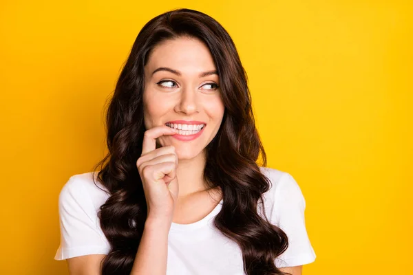 Photo of dreamy cute young woman look empty space bite finger teeth isolated on yellow color background — Foto Stock