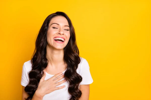 Photo of shiny funny young woman wear white t-shirt laughing arm chest empty space isolated yellow color background — стоковое фото