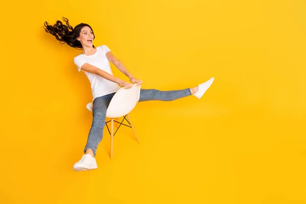 Volledig lichaam profiel zijkant foto van aantrekkelijke vrouw zit stoel vliegen lucht look lege ruimte geïsoleerd op glans gele kleur achtergrond — Stockfoto