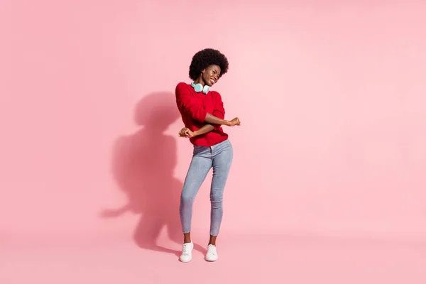 Foto de comprimento total de cabelos castanhos afro-americano menina dança desgaste headset desgaste jeans isolado no fundo cor-de-rosa — Fotografia de Stock