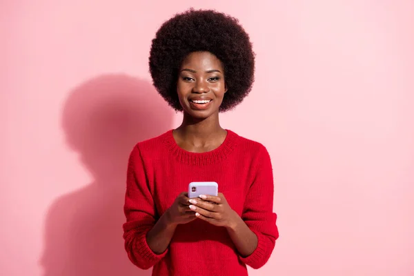 Foto van donkere huid charmante aantrekkelijke vrouw houden smartphone glimlach geïsoleerd op pastel roze kleur achtergrond — Stockfoto