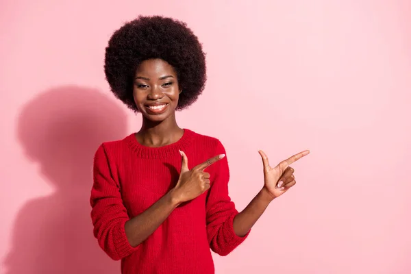 Porträtt av attraktiv glad flicka visar kopia utrymme annons lösning riktning isolerad över rosa pastell färg bakgrund — Stockfoto