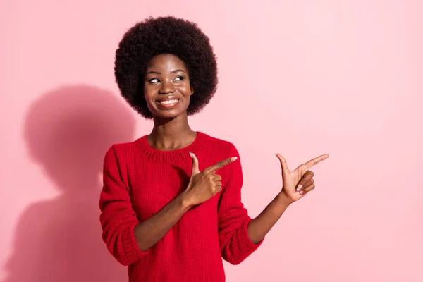 Photo of cheerful dark skin lady look indicate fingers empty space promotion isolated on pink color background — Stok fotoğraf