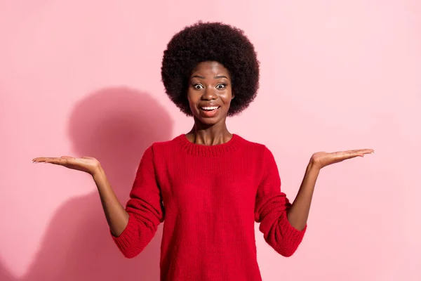 Photo of pretty brunette dark skin lady wear red sweater amazed hold hands empty space isolated on pink color background — Stockfoto