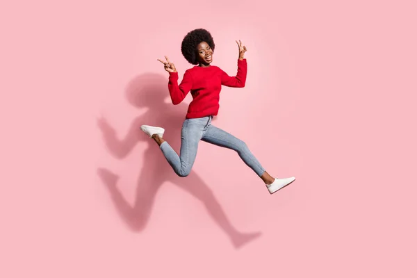 Full length body size view of attractive trendy cheerful girl jumping showing v-sign running isolated over pink pastel color background — Foto Stock