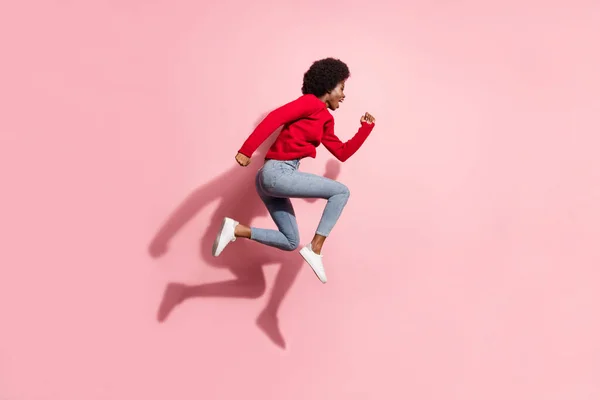 フル長さプロフィール側の写真の暗い肌の女の子ラン空のスペースジャンプアップ隔離されたピンク色の背景 — ストック写真