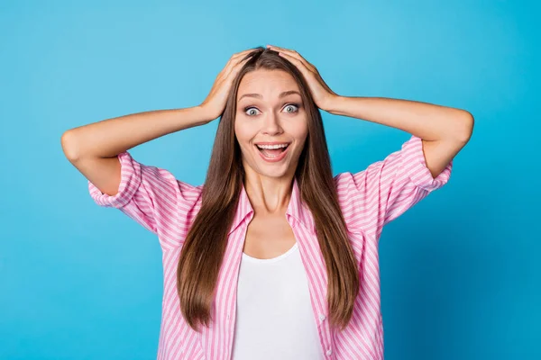 Photo of excited crazy young lady hands hold head open mouth wear pink striped shirt isolated blue background — Stockfoto