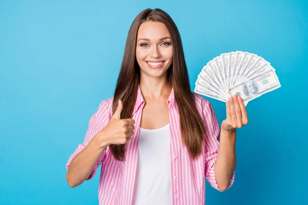 Portrait of optimistic brunette lady hold money show ok wear pink shirt isolated on vivid blue color background — Stok fotoğraf