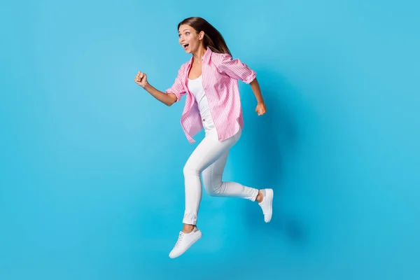 Profile photo of lady jump run look empty space wear pink striped shirt pants footwear isolated blue background — Foto Stock