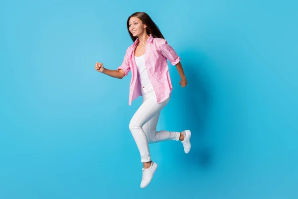 Foto de perfil de lady jump run look espacio vacío desgaste rosa rayas camisa pantalones zapatos aislados fondo azul —  Fotos de Stock